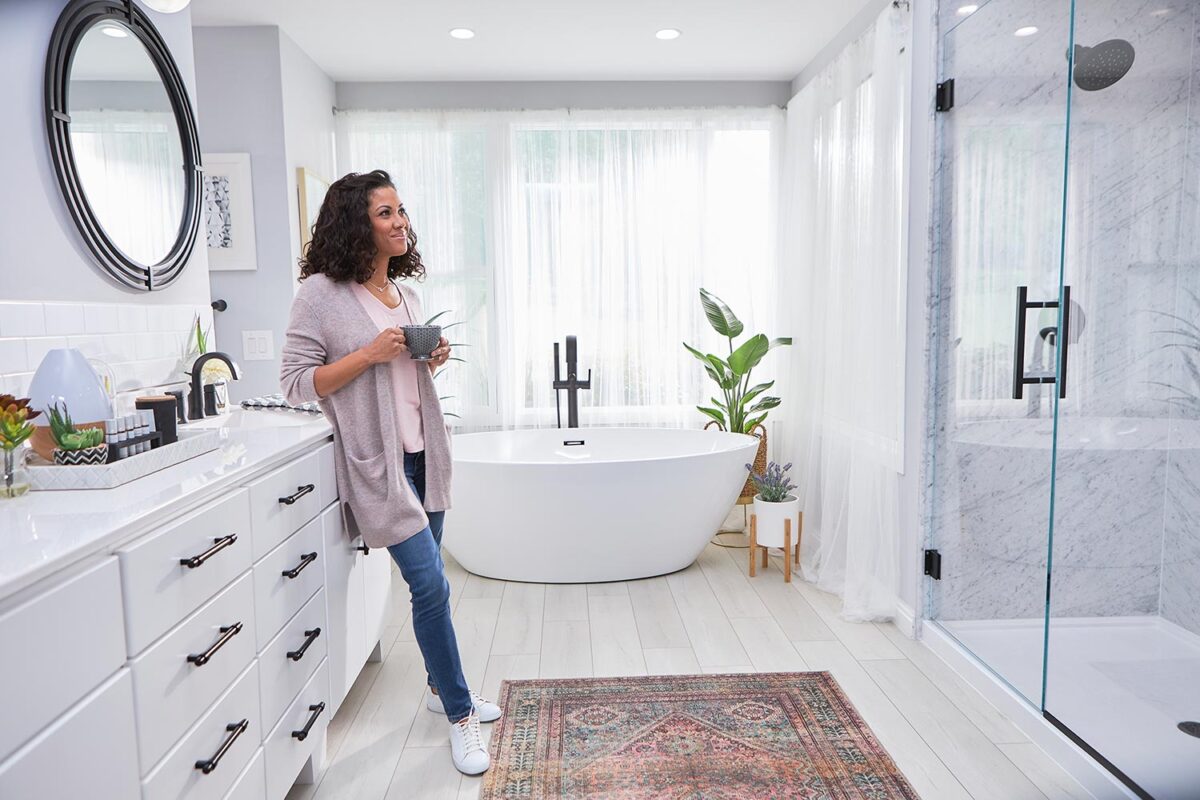 woman smiling in her new modern remodeled bathroom