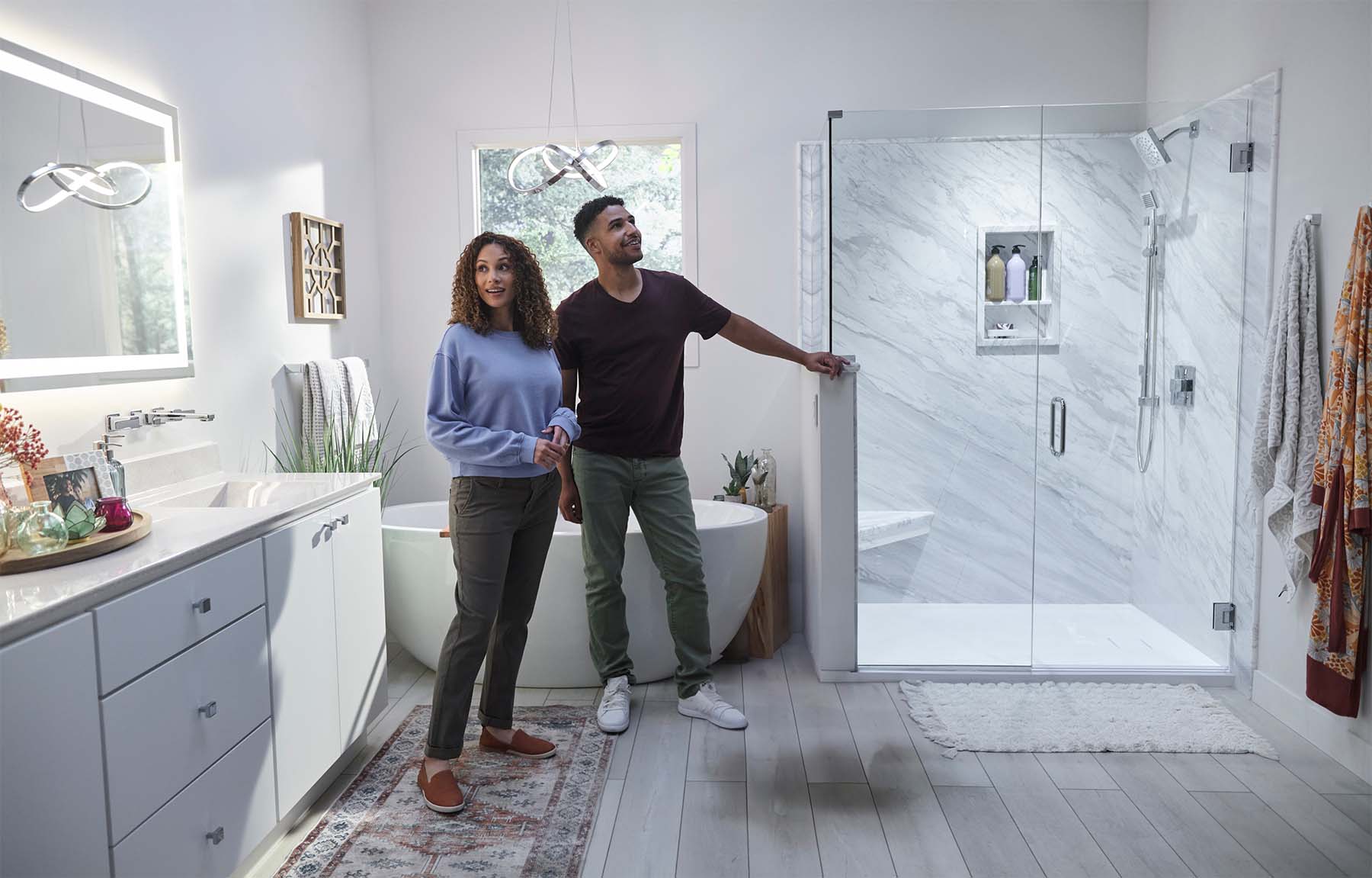 A couple stands in a modern bathroom, showcasing a sleek new bathroom remodel from Re-Bath.